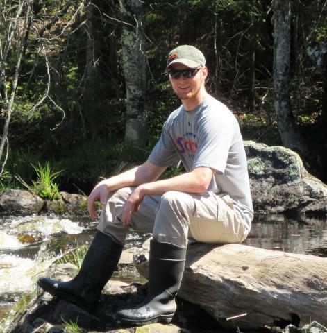 Nolan Kriegel sitting on a log