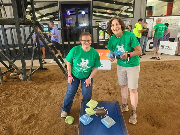 Joan and her team mate tossing bags